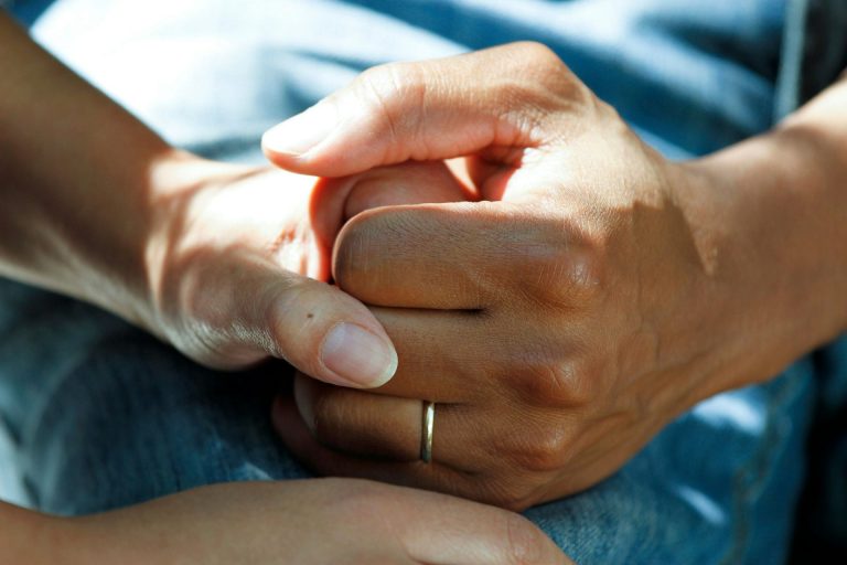 a close up of a people holding hands representing dementia care